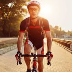 Young man cycling on board walk